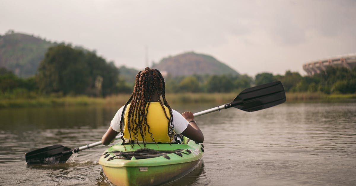 Can I get visas for Nigeria and Ghana in Senegal? - Woman in Yellow and Black Bikini Top Sitting on Green Kayak on River