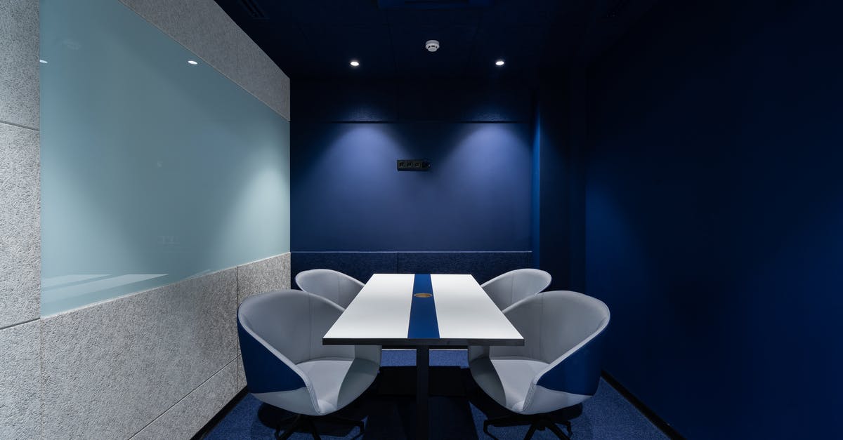 Can I go inside Lebanon during a long transit? - Comfortable chairs placed on carpet at long white desk in modern conference room with blue walls in contemporary business center