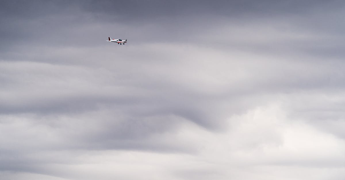 Can I go outside the airport if I'm flying transit, and if visa not required for my citizenship? - White Airplane Flying Under Gray Clouds