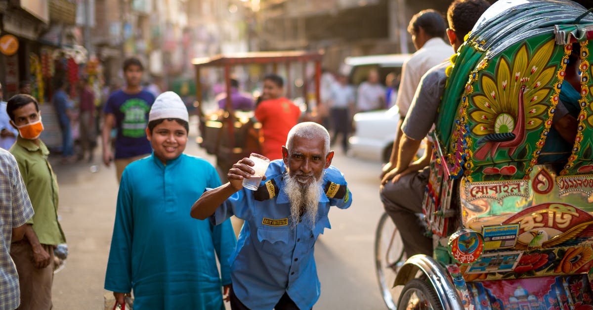 Can I import electronics from India to Bangladesh while traveling? - Photo of a Man Standing Beside Boy