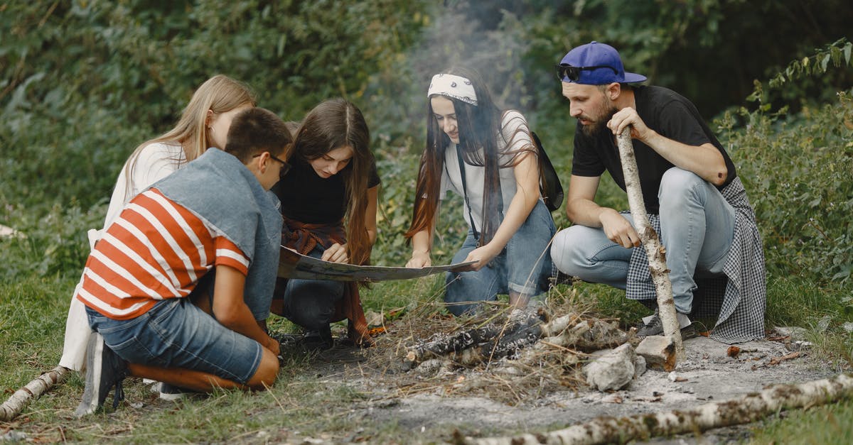 Can I interrupt a journey with an NSB ordinær togbillett? - Young People Looking on Map by a Campfire 