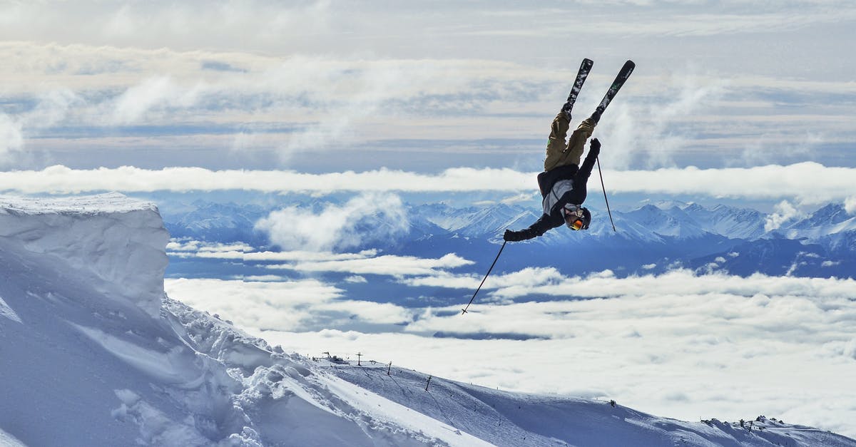 Can I learn ski jumping in Japan? - Fit anonymous male athlete in sports wear and skiis with poles demonstrating difficult acrobatic trick in spectacular mounts covered with snow in daylight