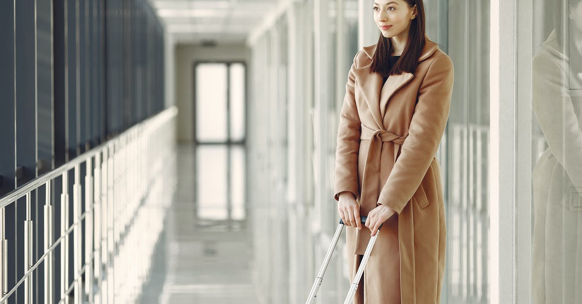 Can I leave the international terminal during a transit stop? - Content woman with suitcase waiting for boarding in airport