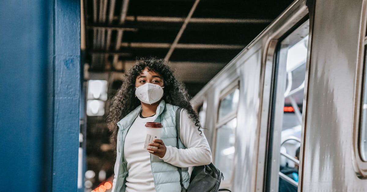 Can I leave the transit area during an EU+Schengen layover? - Black woman in mask leaving metro train