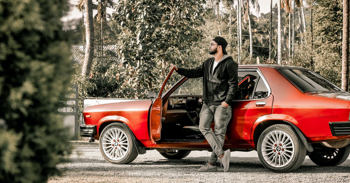 Can I legally drive in France with an Indian driving licence? - Man in Black Jacket and Pants Leaning on Red Car