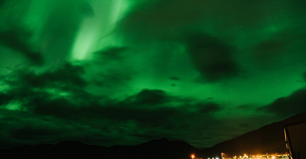 Can I make a short trip to Northern Ireland? - Northern lights over mountain and city