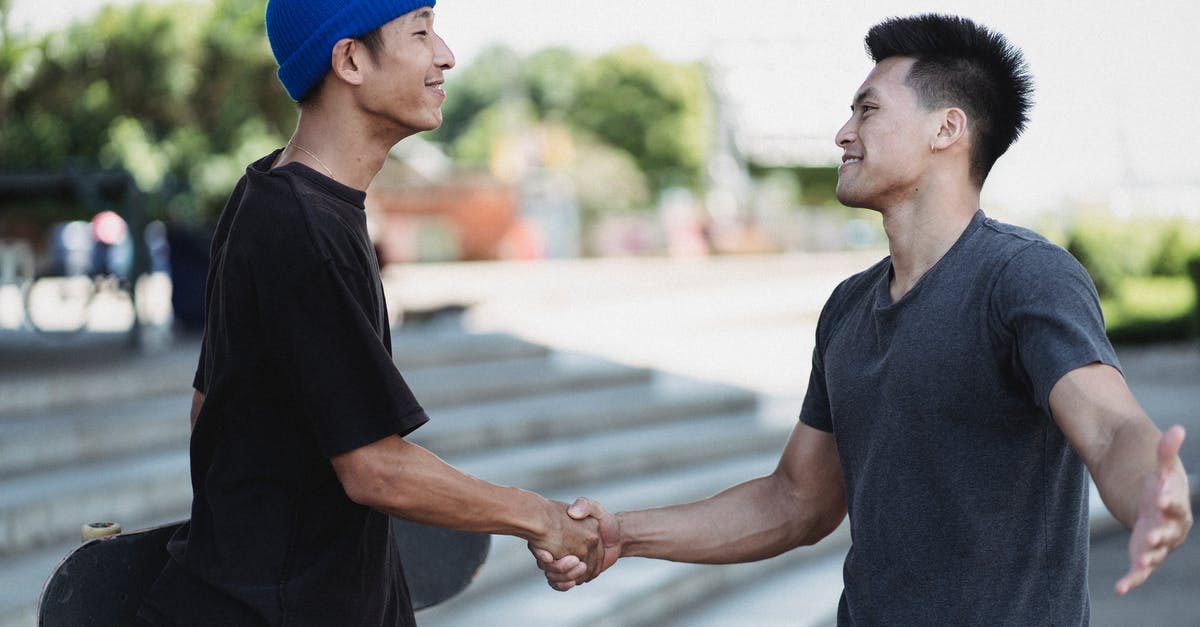 Can I meet my friend during a connecting flight? (LHR) - Content Asian men shaking hands on sunny street