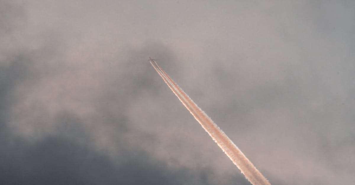 Can I move my flight schedule after VFS interview? - From below of modern aircraft flying in cloudy sunset sky and leaving straight long track