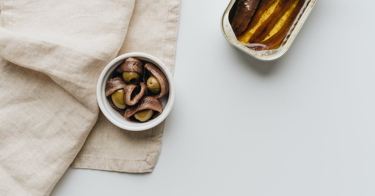 Can I pay with HKD in Macau or Shenzhen? - Close-Up Shot of a Can of Anchovies beside Olives