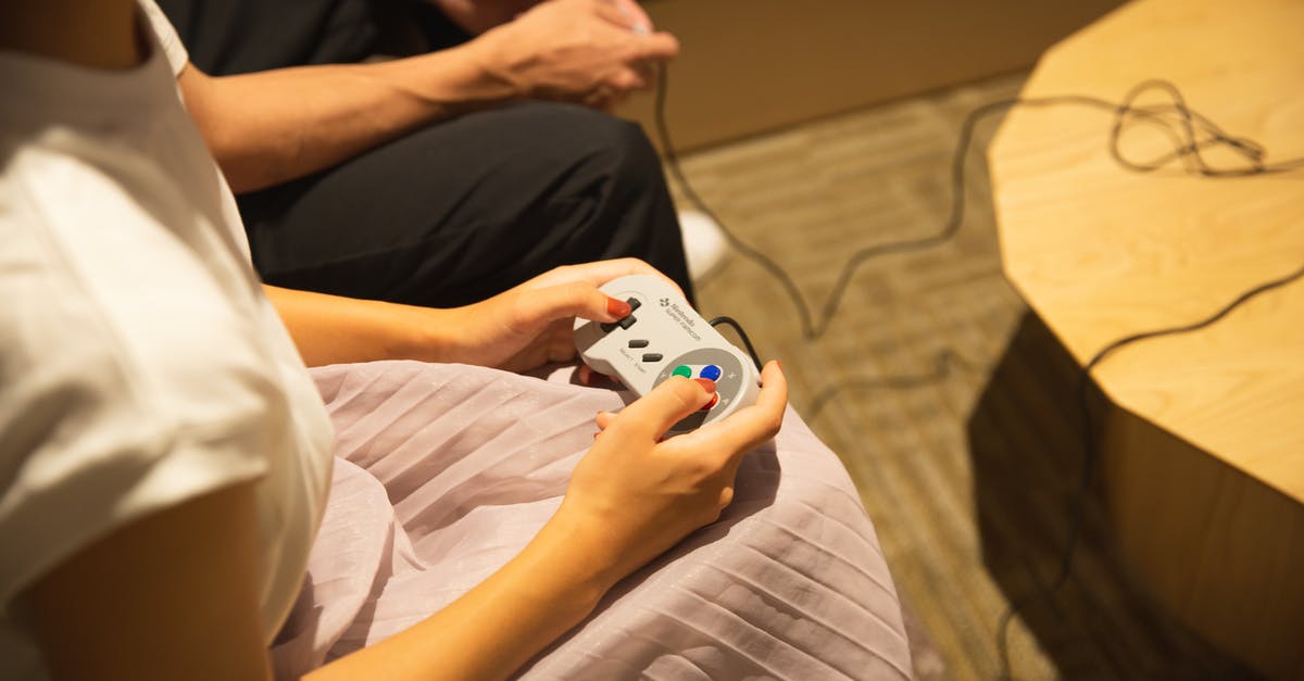 Can I play erotic video games (digital version) in the UAE? - Unrecognizable couple playing video game with gamepads at home