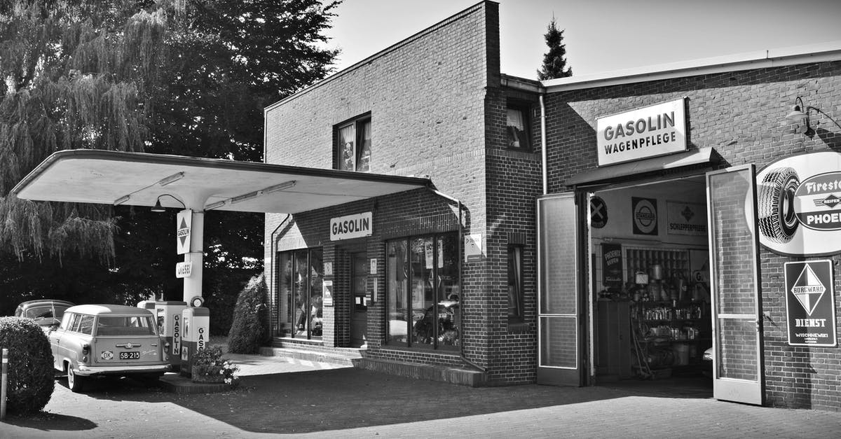 Can I pump my own gas in New Jersey, USA? - Gray Scale Photo of a Sedan Parked Infront of Store