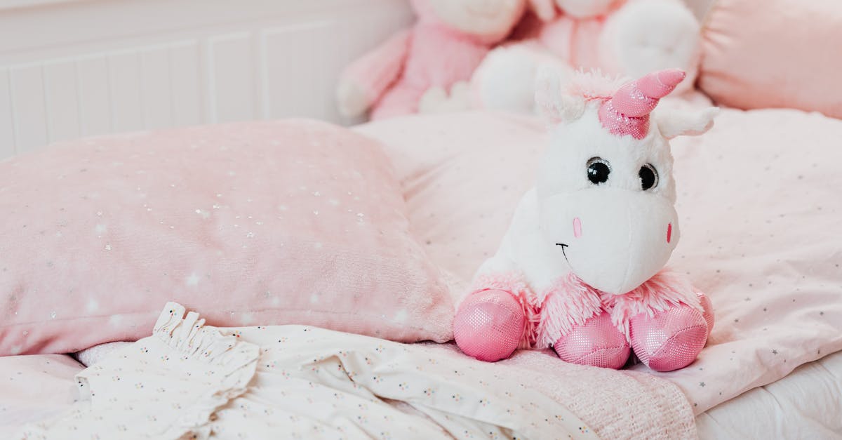 Can I put a bed quilt/blanket in airplane's cargo? - White and Pink Unicorn Plush Toy on Bed