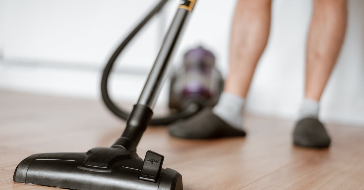 Can I re-enter Hungary if my residence renewal is in process? - Man cleaning floor with vacuum cleaner