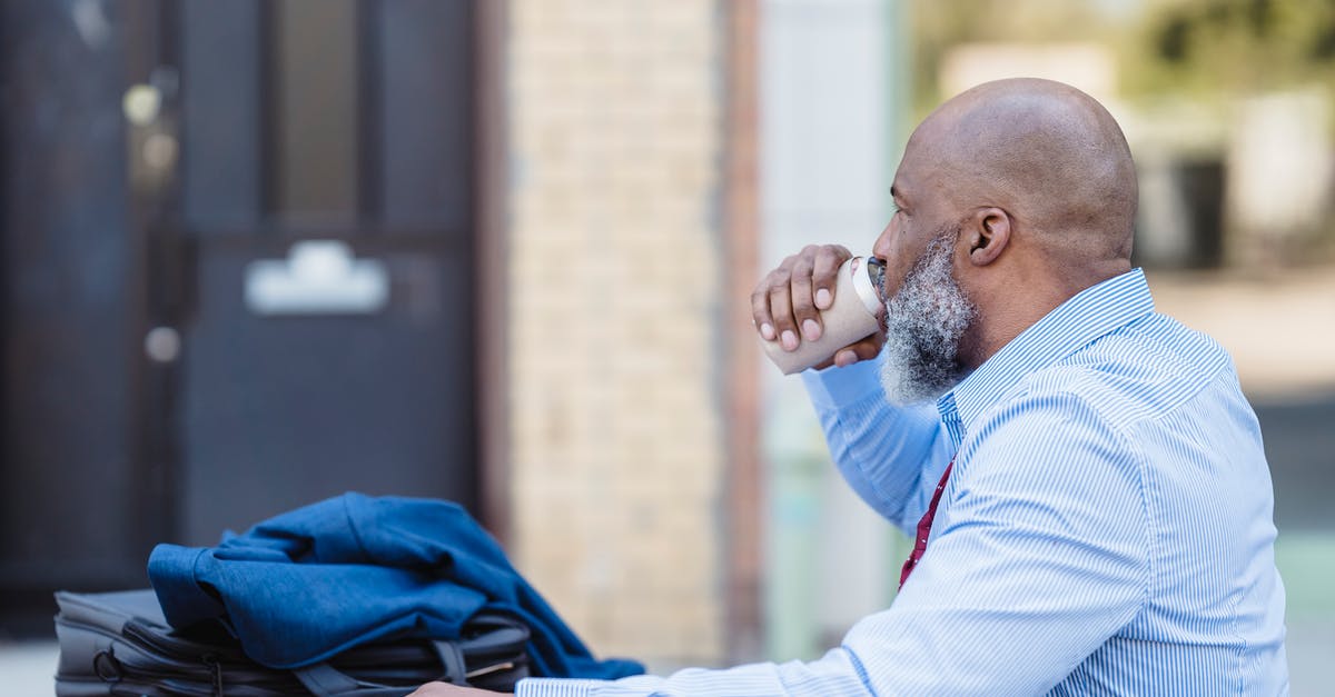 Can I reenter the UK on the visa-free regime? - Side view of elderly bearded African American man in trendy outfit sitting at table with jacket and handbag and drinking beverage from tin can in veranda of cafe