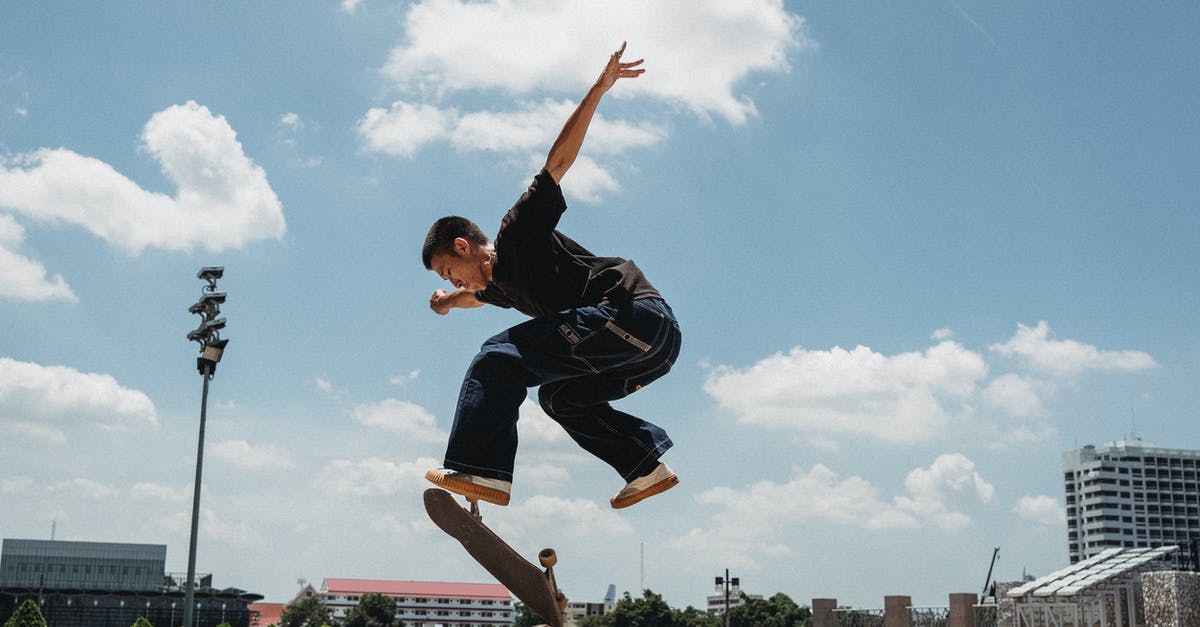 Can I roller skate on the street in France? - Full body of young male skater in casual outfit performing trick on skateboard in city street