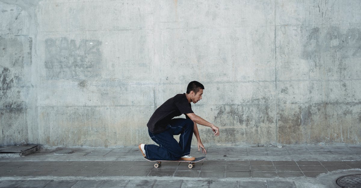 Can I roller skate on the street in France? - Side view of confident male in casual outfit performing trick on skateboard in sidewalk of street