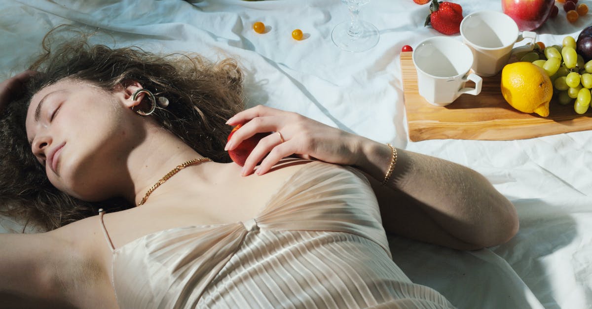 Can I sleep on a airplane tray table? - Relaxed woman with fruit lying on blanket