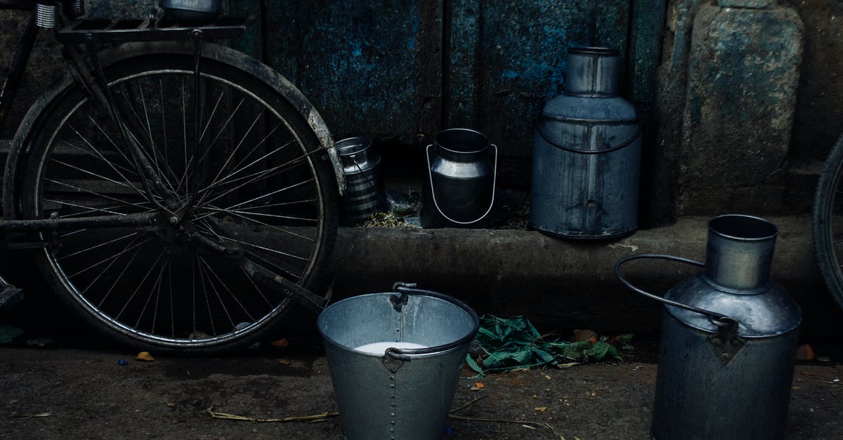 Can I take a folding bicycle (no battery) about 16 inches (weight 7-9 kg) on board without paying extra? - Tin vessels and metal bucket with milk placed near bike leaned on shabby rusty wall