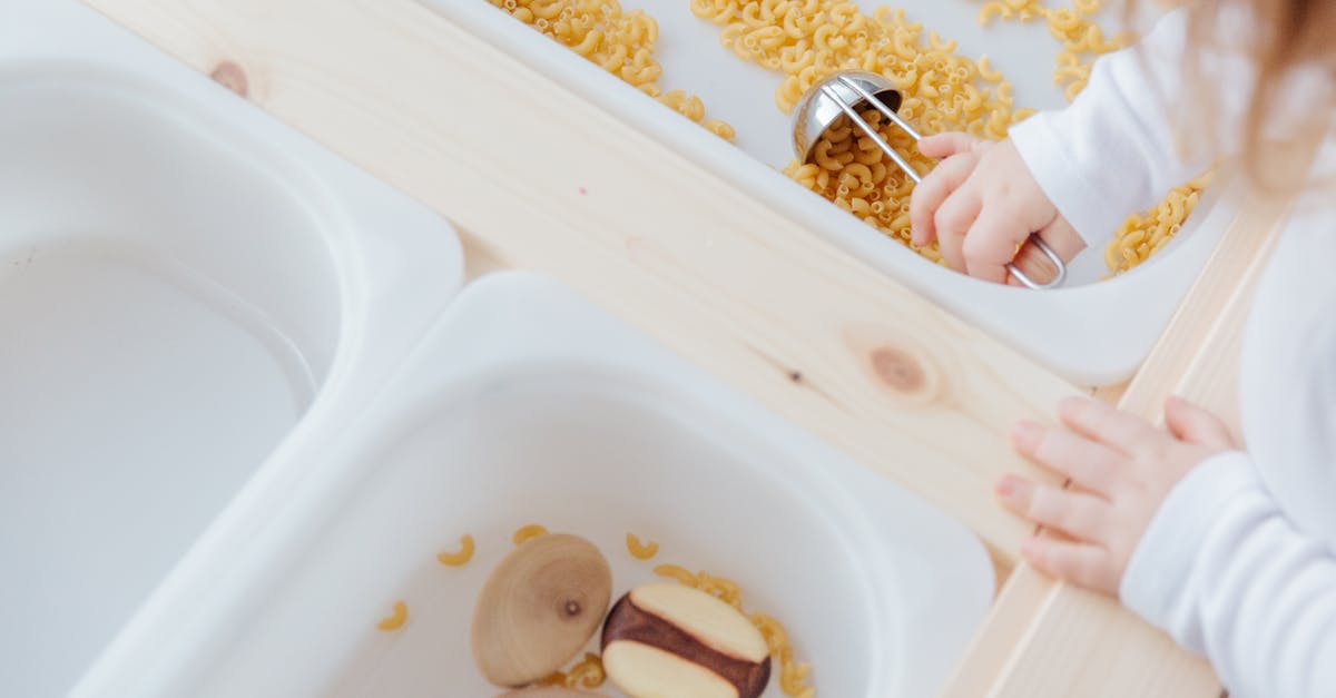 Can I take an AVR development board on a plane? - Little girl collect raw pasta with metal spoon in plastic container