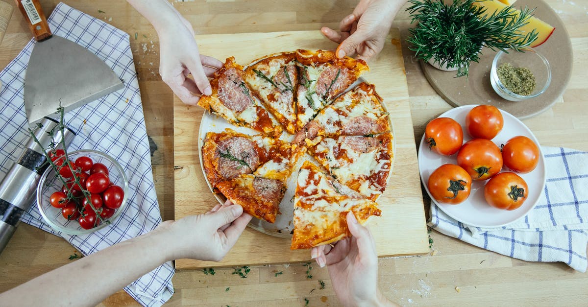 Can I take an extra piece of luggage to the USA? - From above unrecognizable people taking slices of pizza with salami melted cheese and herbs from plate on kitchen table