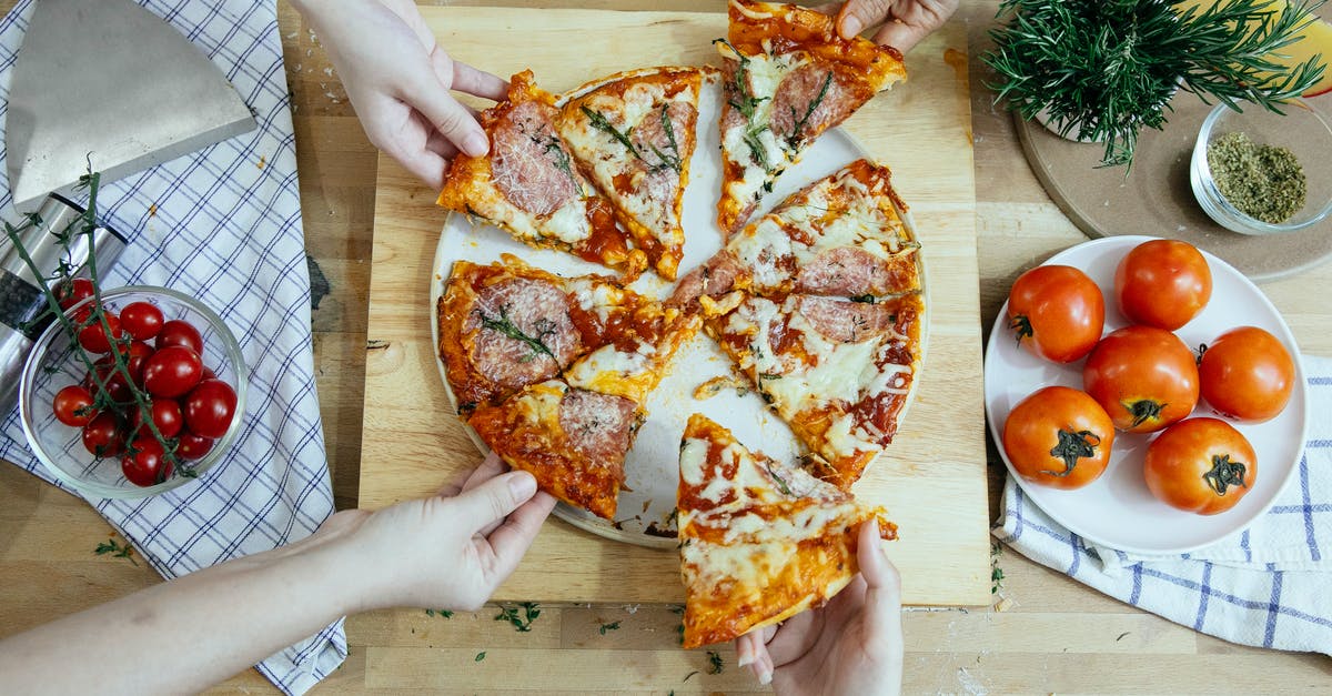 Can I take an extra piece of luggage to the USA? - Crop friends taking slices of delicious pizza from cutting board