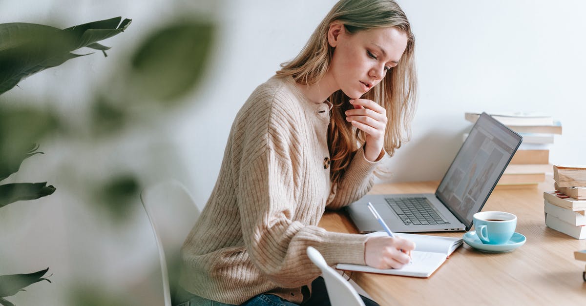 Can I take coffee that has been used and resealed? - Pensive woman taking notes at table with laptop and cup of coffee