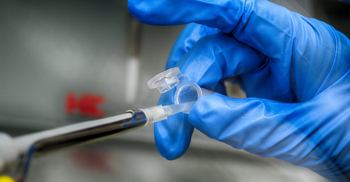 Can I take my liquid medication on a plane? - Crop unrecognizable scientist in blue latex gloves taking sample from plastic tube in modern laboratory