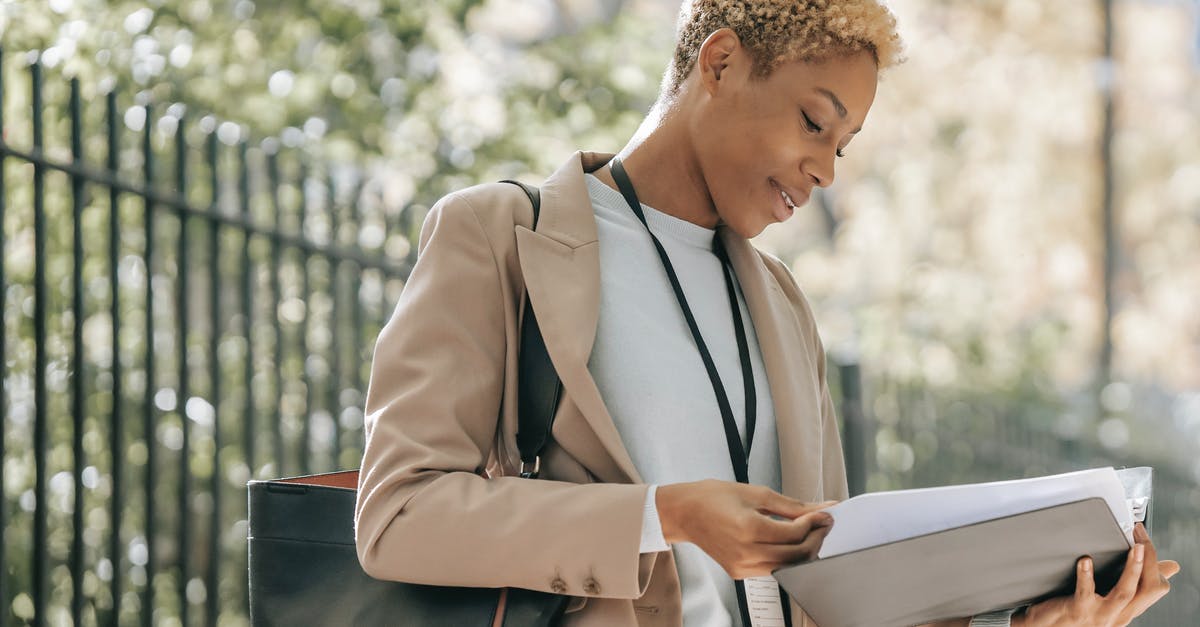 Can I through check my bags on separate bookings (international flights)? - Content ethnic businesswoman looking through papers