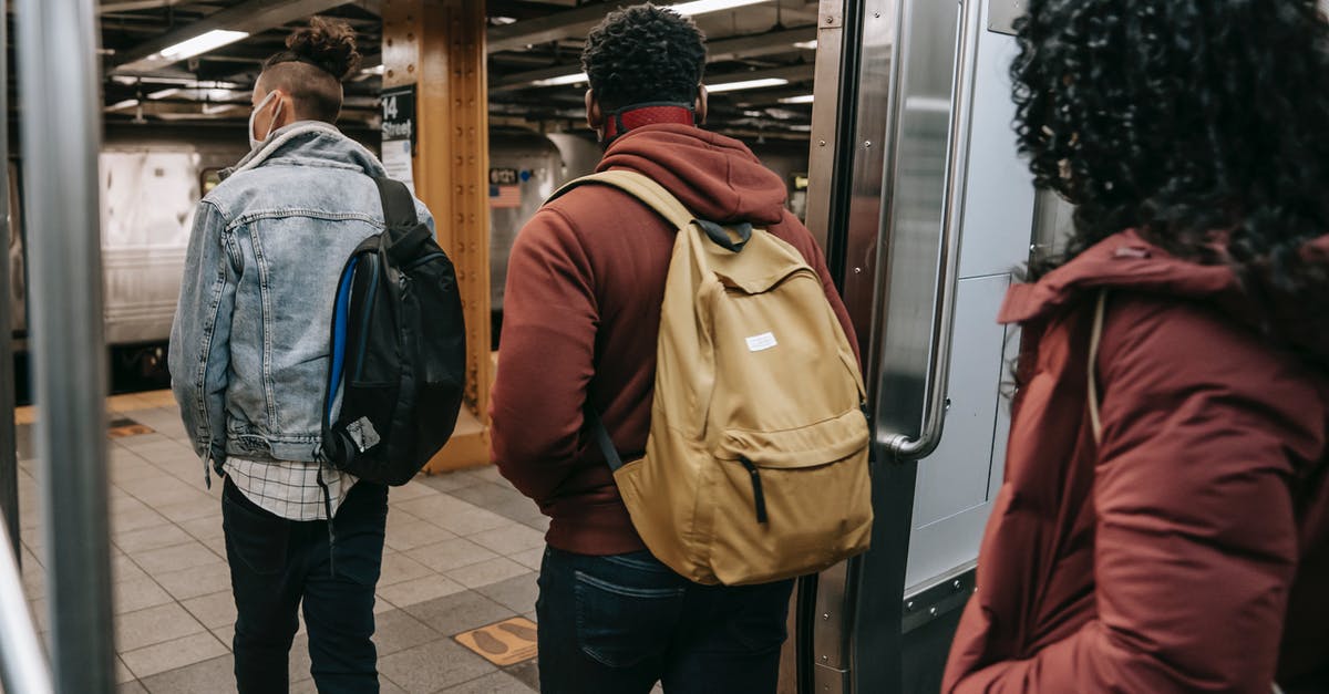 Can I transit in the US with my student visa? - Faceless multiethnic students walking out of subway train