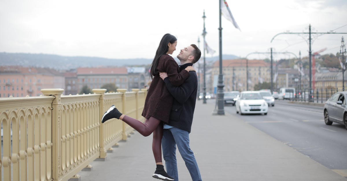 Can I travel between Central Asian cities without flying? [closed] - Full body happy multiethnic couple in casual warm outerwear standing on bridge and hugging while looking at each other on street in city