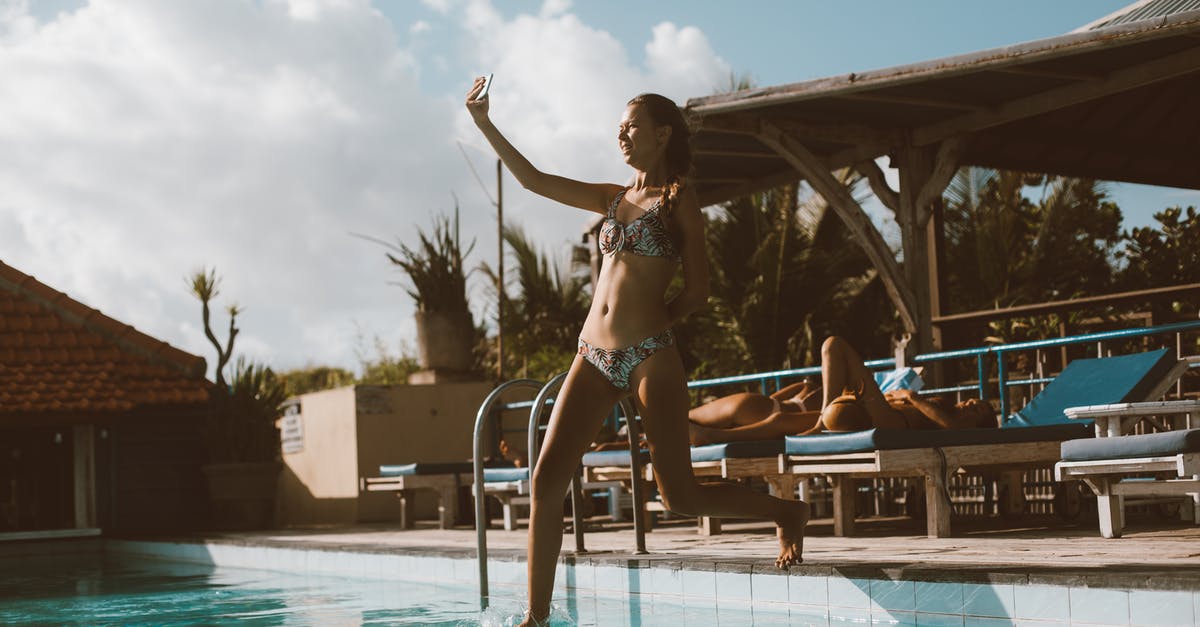 Can I travel from Brussels to Ghent using the JUMP card? - Full body cheerful slim female in swimwear taking selfie on cellphone while jumping into swimming pool in resort on sunny day