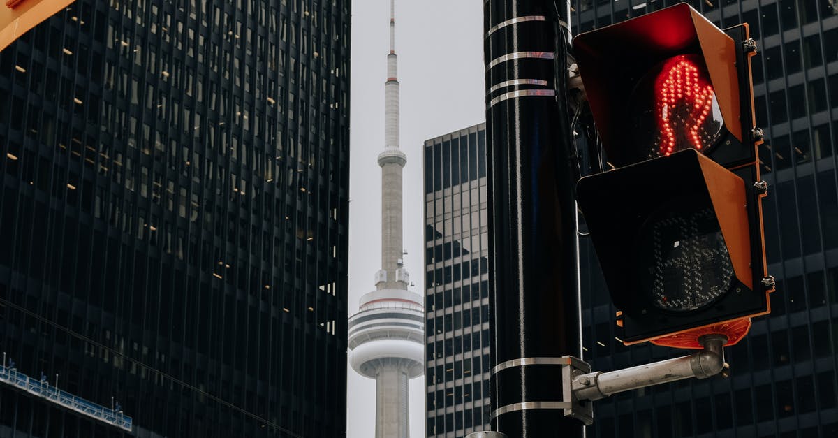 Can I travel from Canada to India via Germany (Frankfurt) - Traffic light with red color and TV tower between skyscrapers