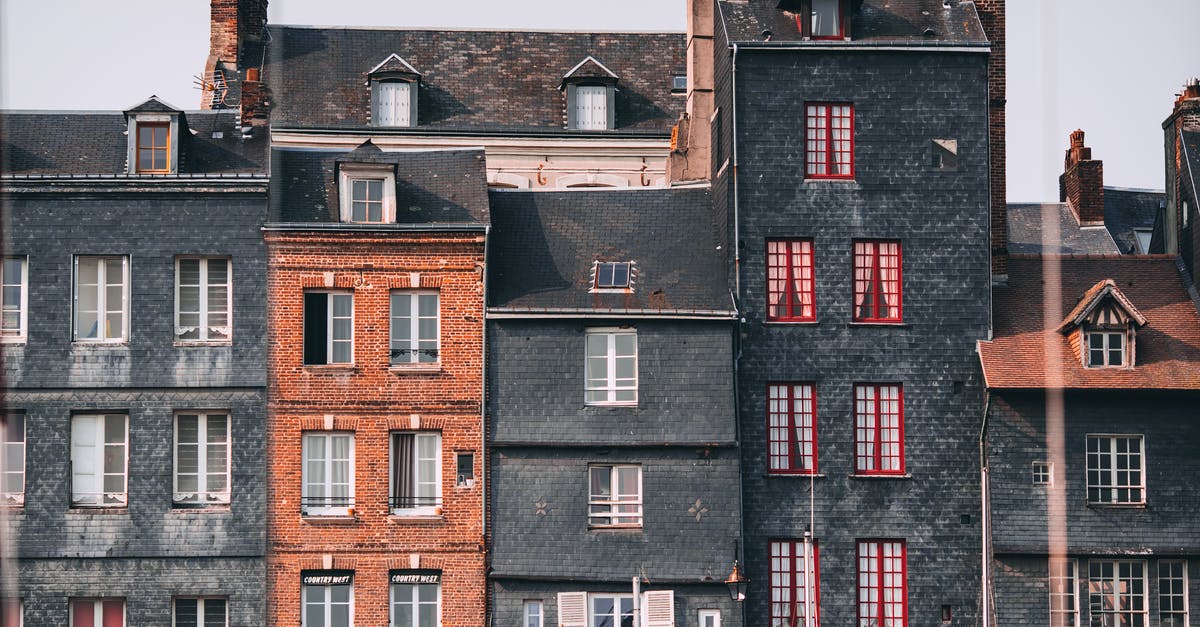Can I travel to France with my UK residence permit? - Row of old historic stone residential houses with chimneys and windows located in Honfleur town on sunny day