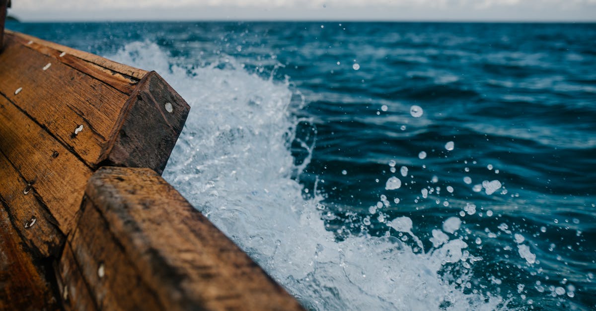 Can I travel to the northern part of Cyprus? - Detail of shabby wooden boat sailing in blue sea and splashing water in summer