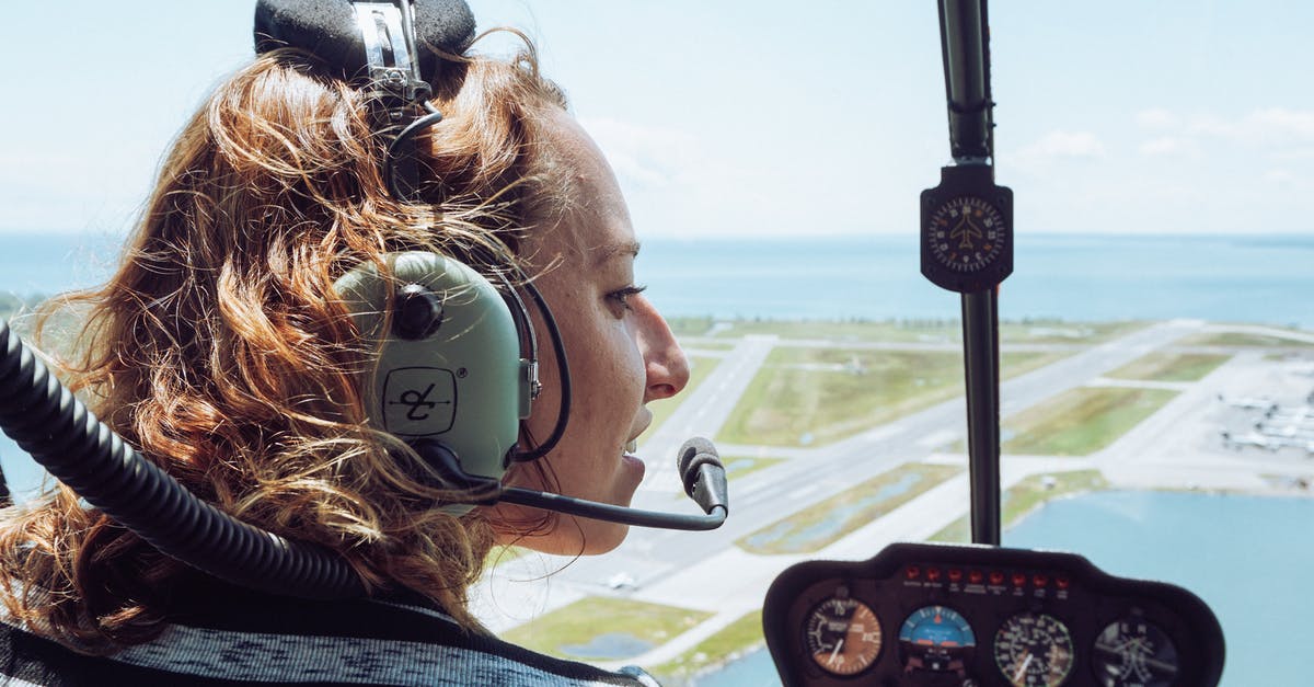 Can I travel to UK as a cabin crew after being refused entry to Ireland? - Back view of positive young female traveler in casual wear and headset sitting in cockpit of modern helicopter during flight over coastal town