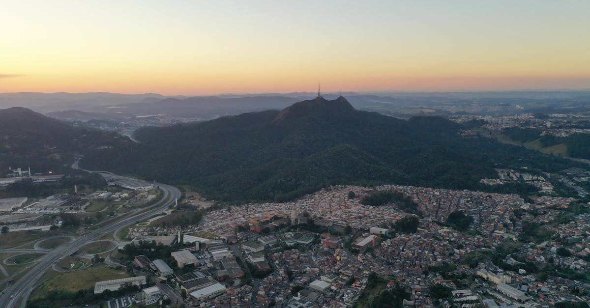 Can I travel within the Schengen area while my Italian residency card is being renewed? - Cityscape near mountain terrain in evening