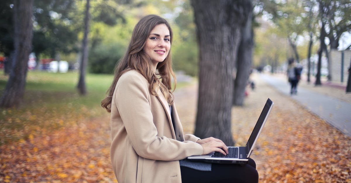 Can I use the SAS lounge after the flight? - Joyful confident woman using netbook in park