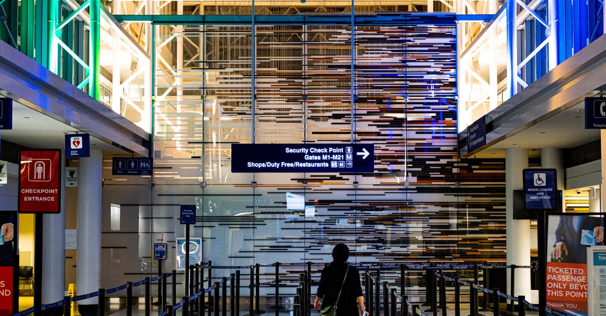 Can I use TSA Pre-check security lines to re-enter an intermediate airport during a layover? - Person Standing Inside Building