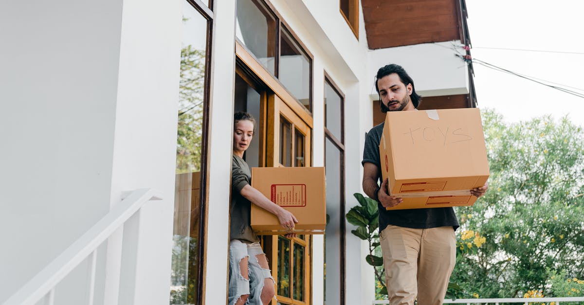 Can I walk out of Brisbane Airport? - Couple carrying carton boxes while moving out of old home