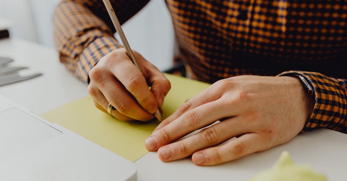 Can I write notes in my passport? - Person Holding Black Pen Writing on White Paper