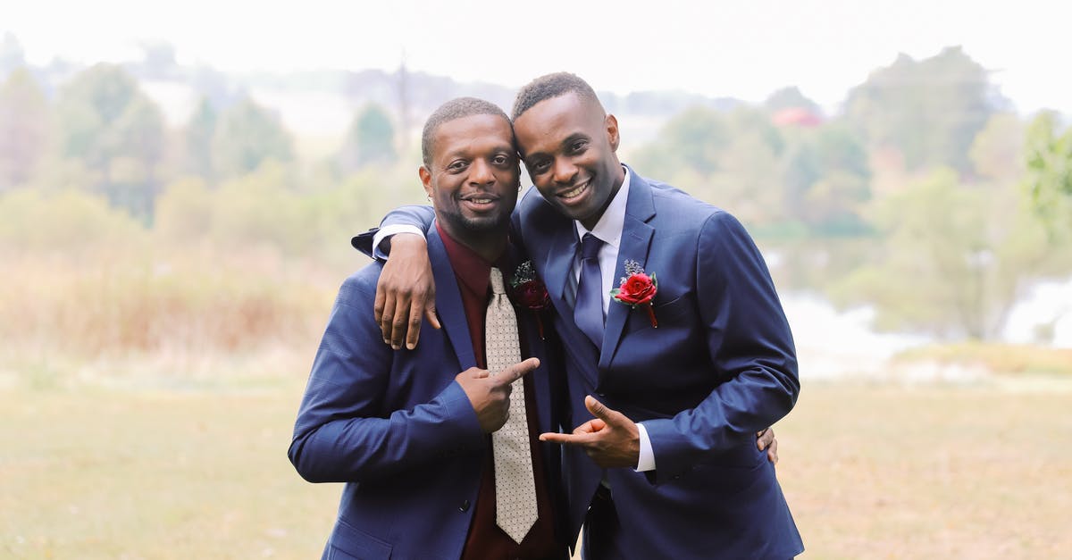 Can my brother photograph my wedding as a tourist? - Black friends in suits pointing at each other