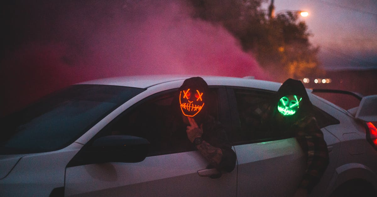 Can my friend legally drive my car in Canada? - Unrecognizable men in glowing Halloween masks driving car at night