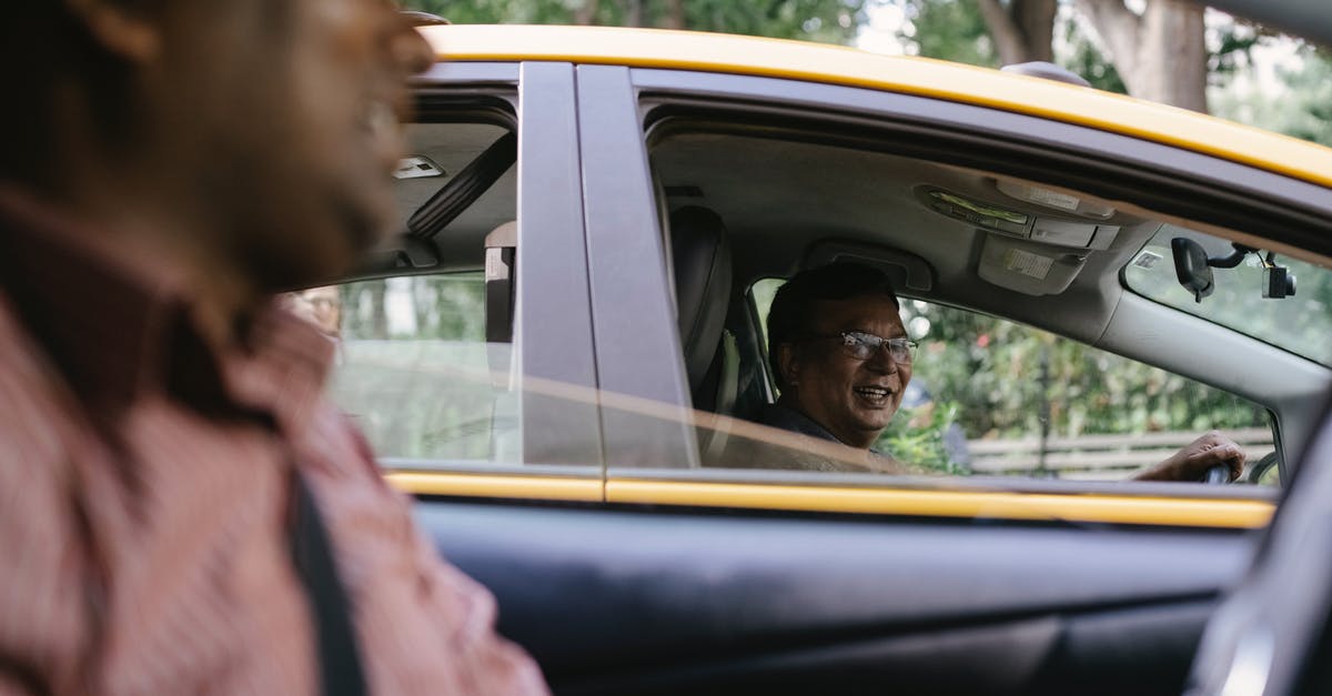 Can my friend legally drive my car in Canada? - Crop cheerful diverse taxi drivers talking in cars