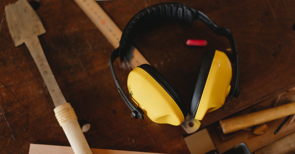 Can Noise Cancelling headphones block the overhead PA on a plane? - Protective headphones near carpentry tools on workbench