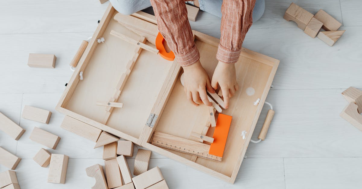 Can one take wooden toys to Australia? - Person in Pink and White Plaid Pants Holding Brown Wooden Box