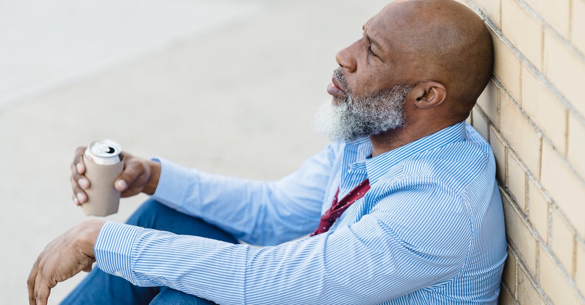 Can shaving my head cause problems entering the US? - Depressed black male with beer can leaning on brick wall