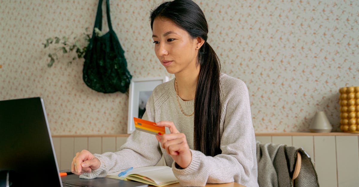 Can tickets for buses in Perú be purchased online? - Woman Holding a Card While Using a Laptop