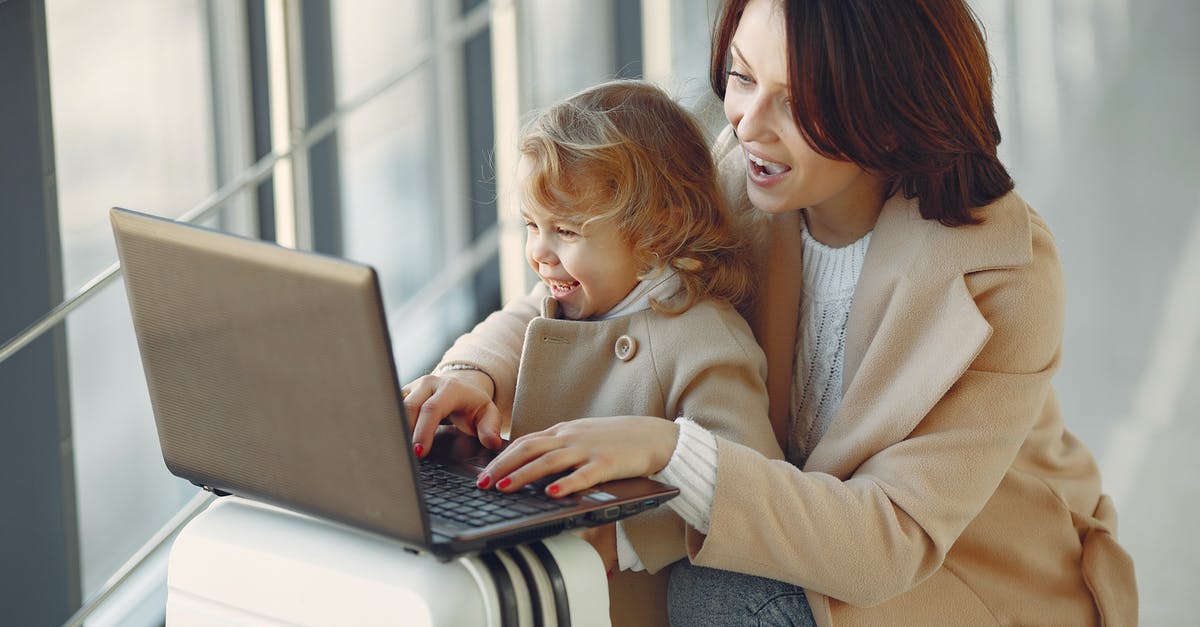 Can we round-trip travel to Brazil from the USA with our 5-month-old daughter using just her birth certificate? - Cheerful stylish woman with suitcase hugging adorable laughing daughter and browsing laptop together while waiting for flight in airport hallway