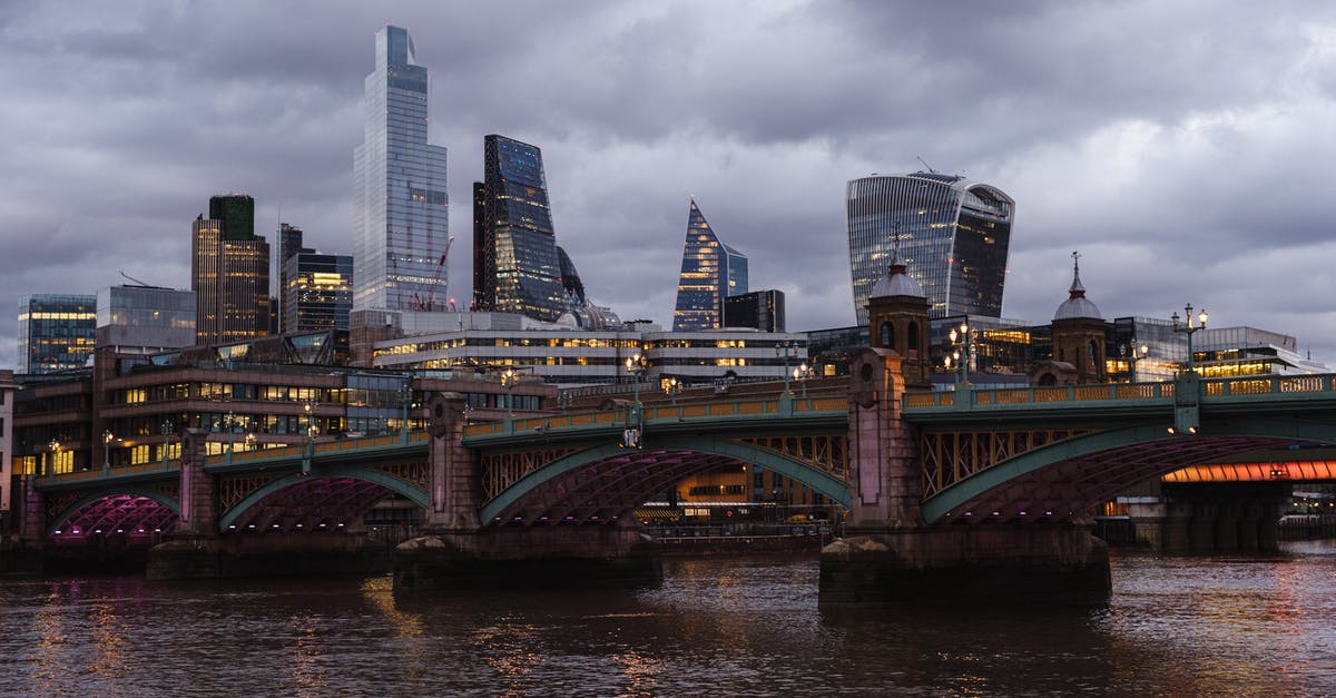 Can you apply for a UK Visa in a location that is not your residence? - Bridge with glowing lights crossing calm Thames river located against contemporary famous multistory office buildings in London on evening time