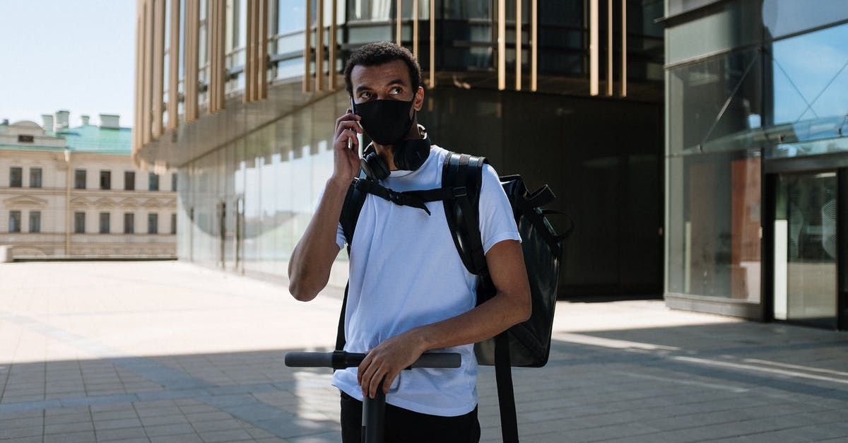 Can you bring an electric scooter on Flixbus? - Man in Blue Polo Shirt and Black Backpack Standing on Sidewalk